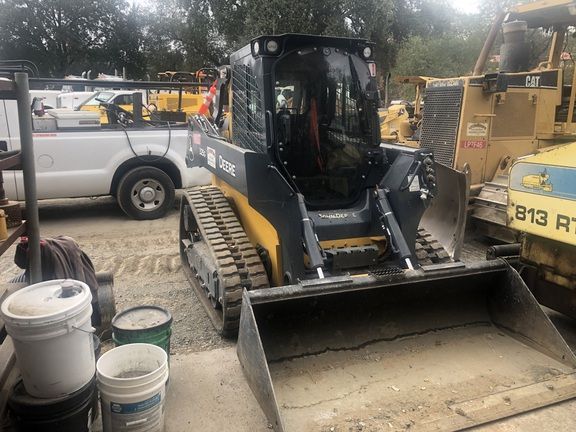 En kompakt John Deere bandlastare redo för entreprenadarbete.