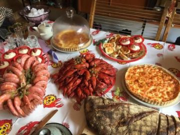 Dukat bord för kräftskiva med berg av kräftor, västerbottensostpaj och bröd.